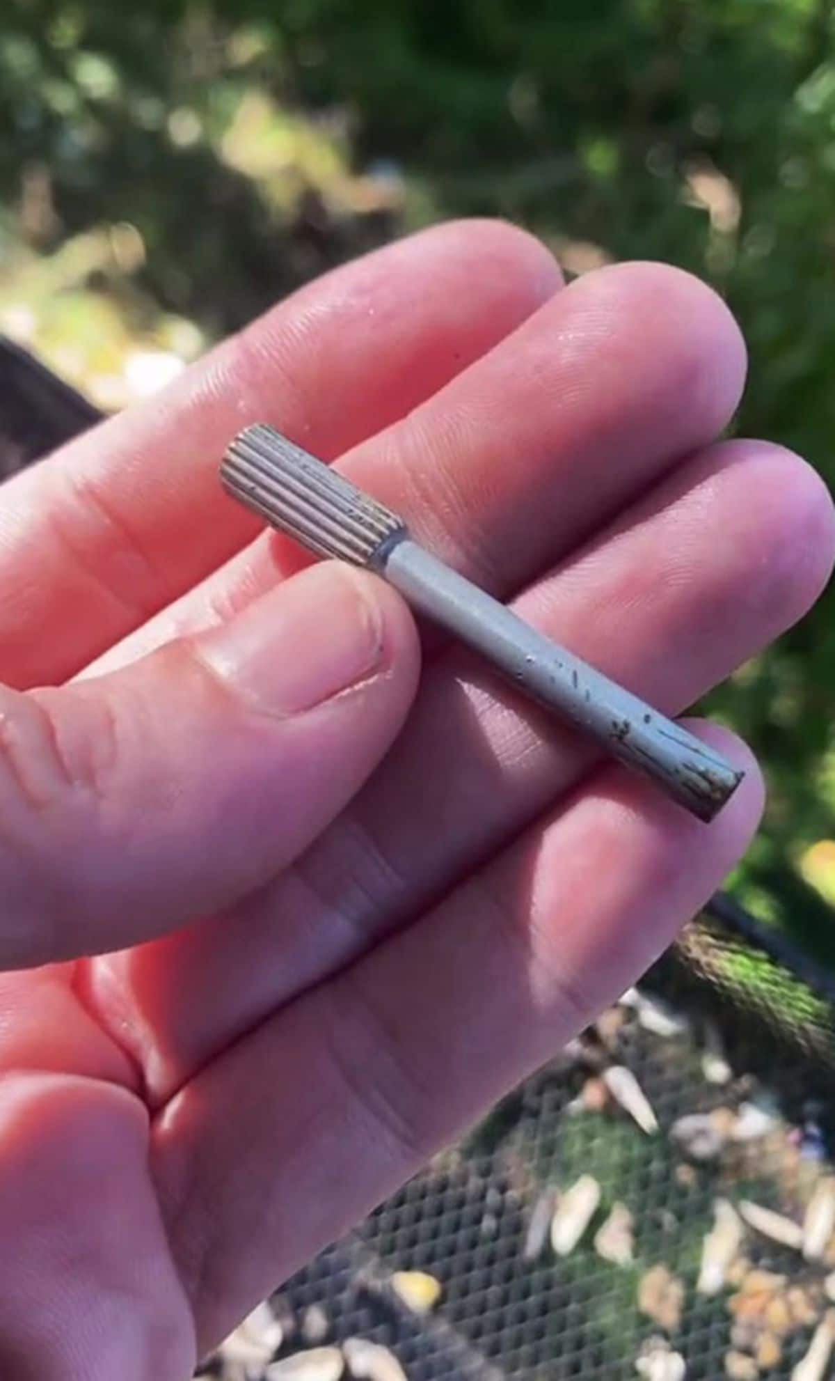 a small grey metal item held in someone's hand