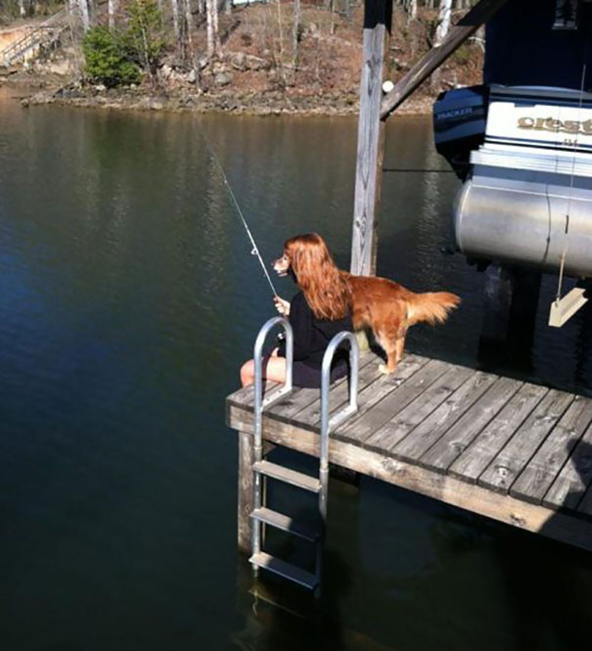 golden retriever standing next to a woman with red hair fishing looking like she has the dog's face