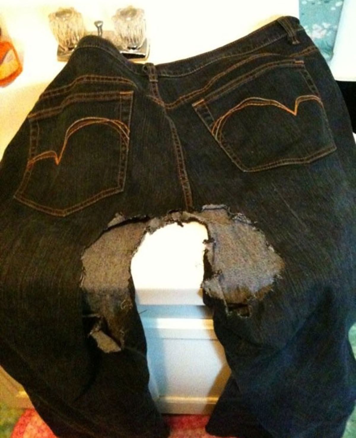 black denim jeans with the crotch area ripped up by a dog