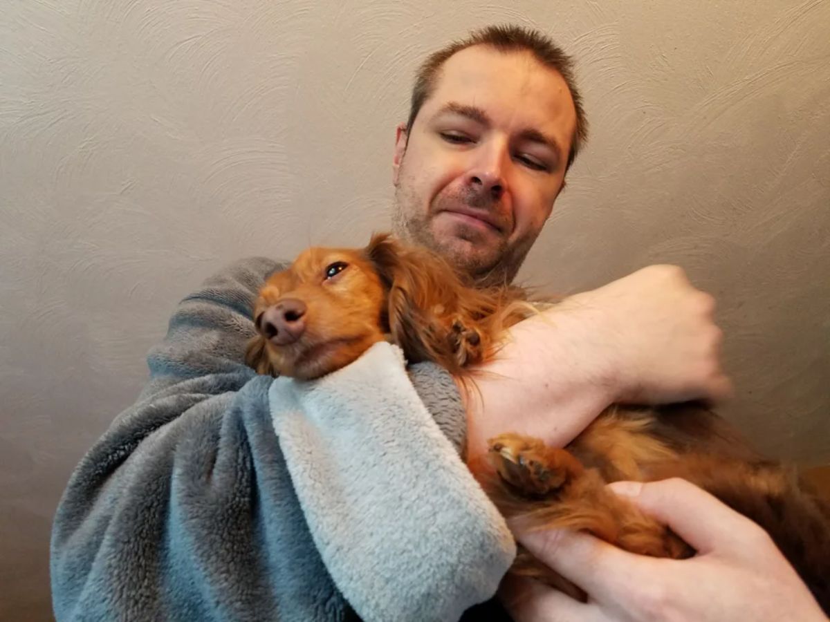 man hugging a fluffy brown dog