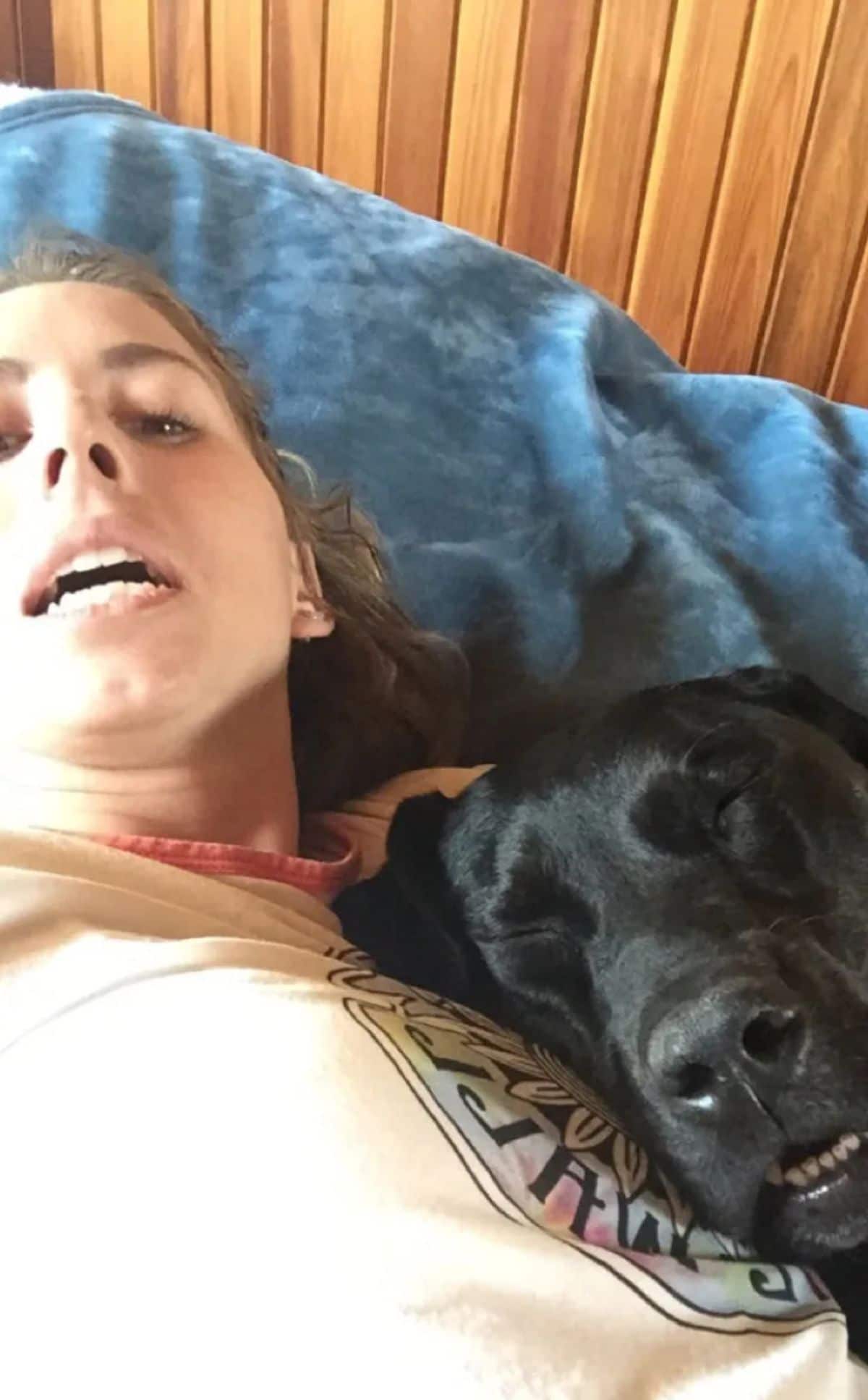 sleeping black dog with the mouth open and a woman with her mouth open