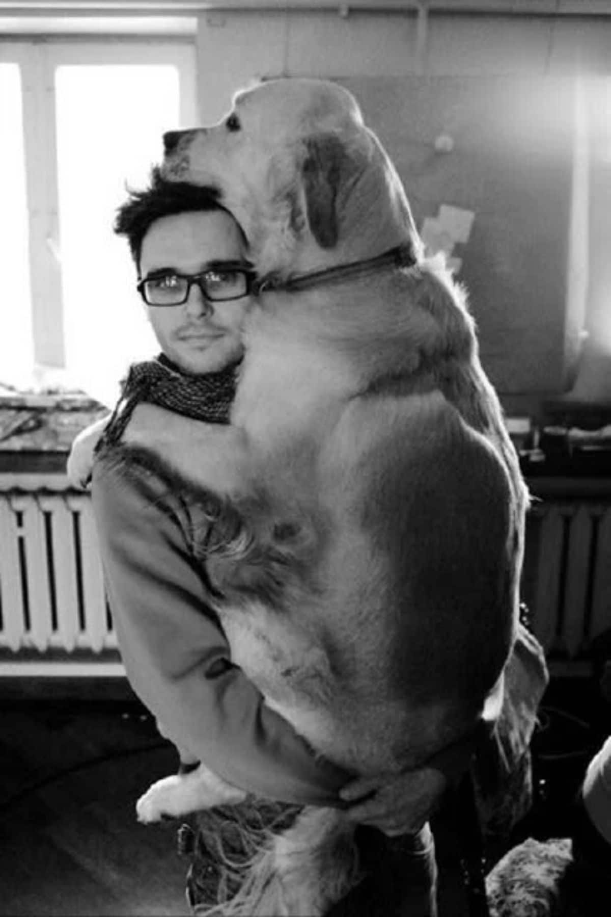 black and white photo of a large dog being carried by a person