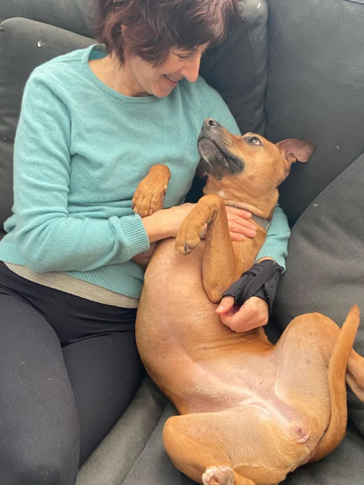 brown dog being hugged by a woman and they are looking at each other lovingly