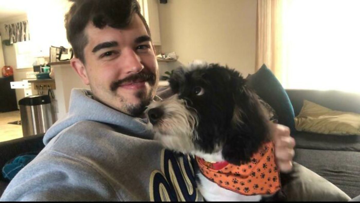 fluffy black and white dog looking lovingly at a man