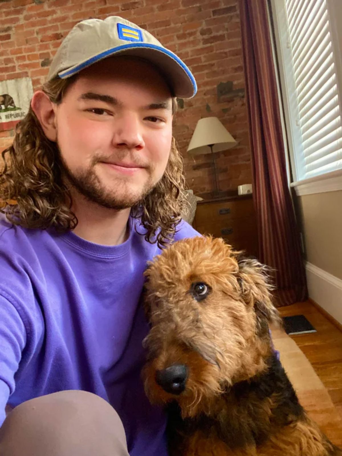 fluffy brown and black dog being held by a man and looking up at the man lovingly